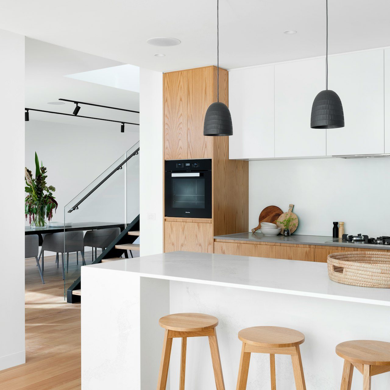 Conception cuisine coulommiers Cuisine moderne avec comptoir en marbre, tabourets en bois et décoration épurée.
