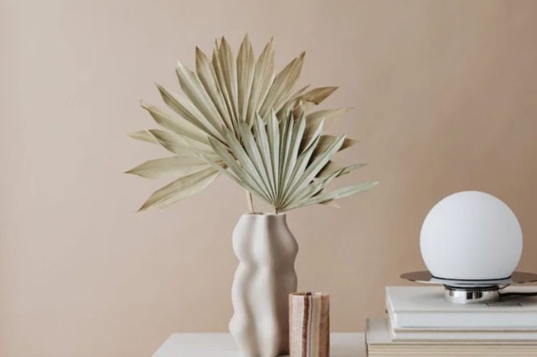 Coaching déco avec jeune femme présentant une photo de cheminée et un nuancier de couleurs dans les tons de roses orangés et jaunes à sa cliente qui est face à elle